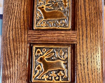 Azulejos con motivos de criaturas del bosque de Motawi en marco de roble estilo misión.