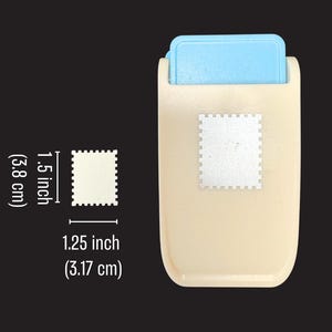 May include: A beige and light blue craft paper punch with a rectangular stamp-shaped cutout design. The punch creates a shape measuring 1.5 inches by 1.25 inches, as indicated by the white measurement labels printed next to the tool.