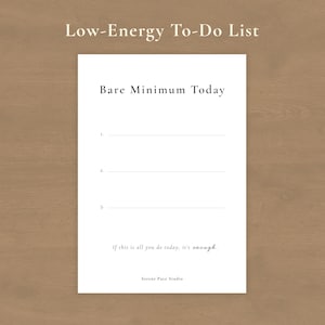 Könnte beinhalten: Ein weißes Papier mit der Aufschrift "Low-Energy To-Do List" mit dem Text "Bare Minimum Today" und drei nummerierten Zeilen. Der untere Teil der Seite lautet "If this is all you do today, it's enough." und "Serene Face Studio."