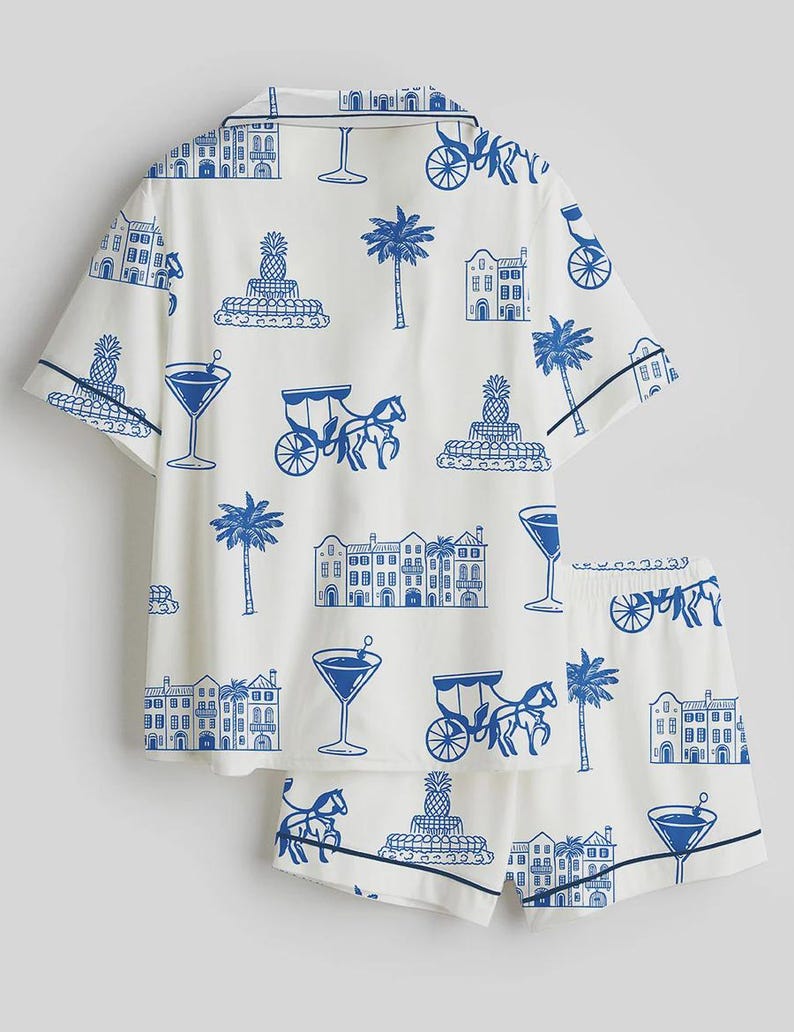 K&ouml;nnte beinhalten: Wei&szlig;es Pyjama-Set mit blauem Aufdruck mit Cocktails, Kutschen, Geb&auml;uden, Palmen und Ananas. Das Set besteht aus einem kurz&auml;rmeligen Hemd und passenden Shorts mit marineblauen Paspeln.