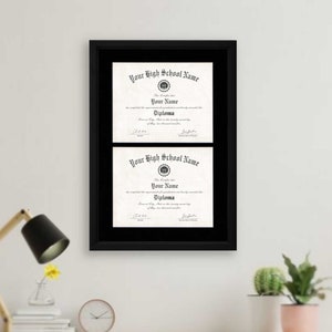 May include: Black framed double diploma display with two high school diplomas. The diplomas are printed on parchment paper with black text. The diplomas are for "Your High School Name" and "Your Name".