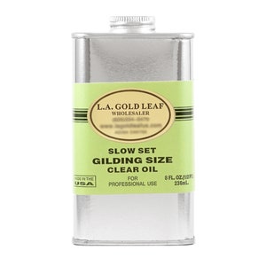 May include: A silver can of L.A. Gold Leaf Slow Set Gilding Size Clear Oil for professional use. The can is labeled with the company name, product name, and size: 8 fl. oz. (1/2 pt) 236 mL. Made in the USA.