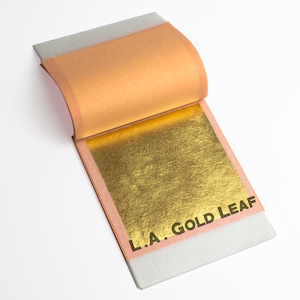 May include: A book of gold leaf, with the gold leaf visible and the text "L.A. GOLD LEAF" printed on the cover.