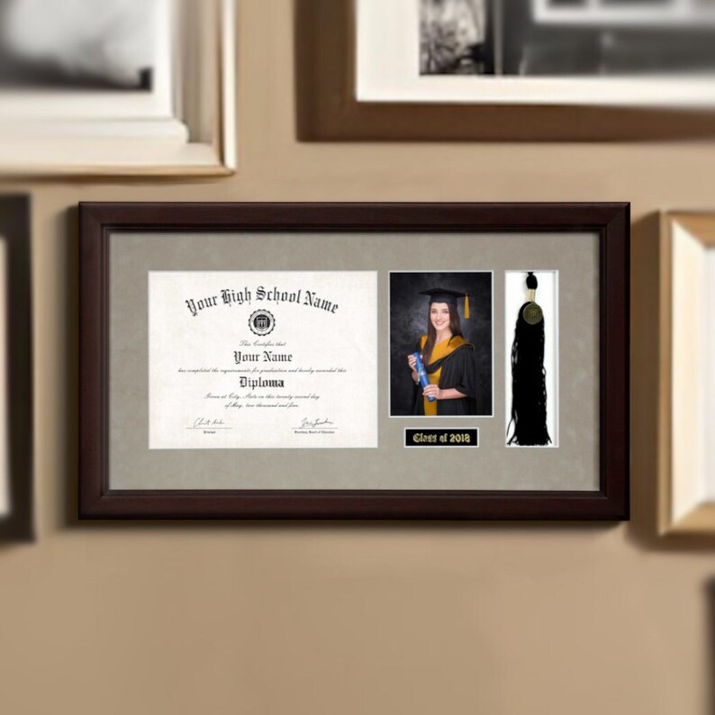 May include: A framed diploma with a black tassel and a photo of a graduate in a cap and gown. The diploma reads "Your High School Name" and "Diploma". The photo is captioned "Class of 2018".