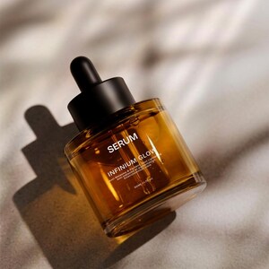 Puede incluir: Botella de s&eacute;rum color &aacute;mbar con tap&oacute;n cuentagotas negro. La botella est&aacute; etiquetada como "SERUM" e "INFINIUM GLOW". El producto est&aacute; en &aacute;ngulo, proyectando una sombra sobre una superficie de tono neutro. La botella contiene 50 ml de s&eacute;rum.
