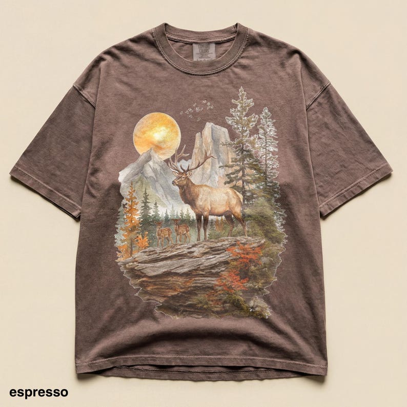 K&ouml;nnte beinhalten: Espressofarbenes T-Shirt mit Berg- und Elch-Grafik. Das Design zeigt einen Elch, B&auml;ume, Berge und einen Vollmond. Das Shirt hat kurze &Auml;rmel und einen Rundhalsausschnitt.