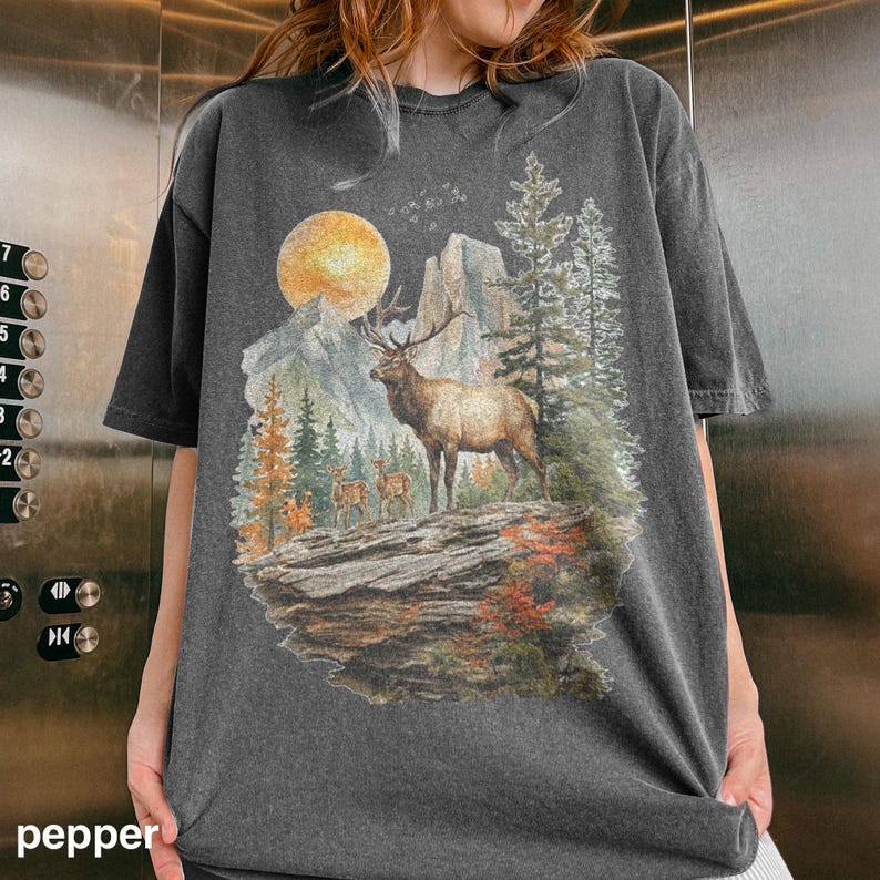 K&ouml;nnte beinhalten: Dunkelgraues T-Shirt mit einem Berg- und Elch-Motiv, B&auml;umen und einem Vollmond. Das Design hat einen Vintage- und Outdoor-Look. Das Wort "pepper" ist unten auf dem Shirt aufgedruckt.