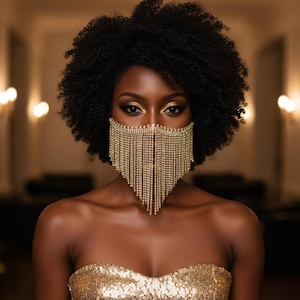 Puede incluir: Una mujer con piel oscura y cabello rizado, que lleva un top sin tirantes dorado con lentejuelas y una máscara facial decorativa hecha de brillantes dorados colgantes. La mujer tiene maquillaje de ojos dorado.