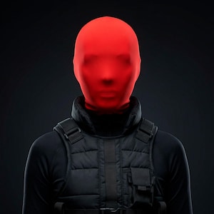 Op de afbeelding: Een persoon draagt een felrode volledige gezichtsbedekking, een zwarte coltrui en een zwart tactisch vest. Het vest heeft meerdere zakken en bandjes. De achtergrond is donkergrijs.