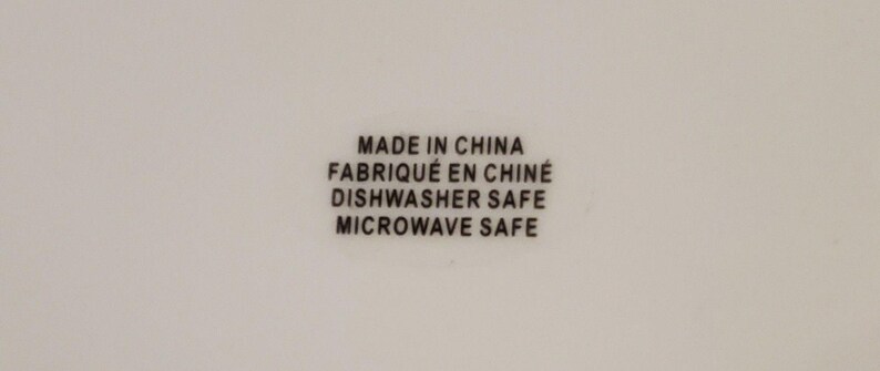 May include: White background with black text that reads "MADE IN CHINA", "FABRIQU&Eacute; EN CHINE", "DISHWASHER SAFE", and "MICROWAVE SAFE". The text is centered and in a sans-serif font.