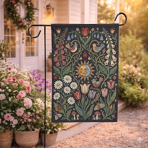 Può includere: Una bandiera da giardino nera con un design floreale stravagante con uccelli, margherite, tulipani e un motivo sole e luna. La bandiera è esposta all'aperto, aggiungendo un tocco decorativo a un giardino.