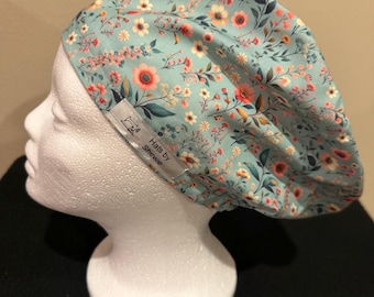 Gorro quirúrgico estilo europeo con estampado floral verde, parte superior tipo gallina y elástico ajustable.