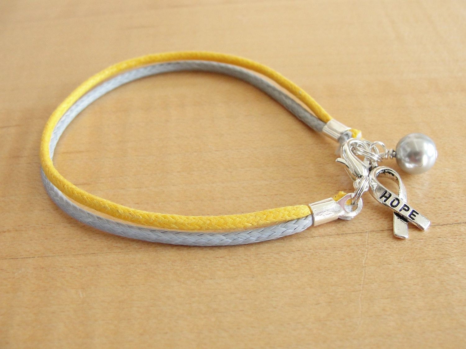 Amazon.com: Childhood Cancer Awareness Gold Ribbon Support Friendship  Bracelet, Handmade Small 18K Gold Plated Ribbon Shaped Charm with Black  Adjustable Thread Cord, GO GOLD : Handmade Products