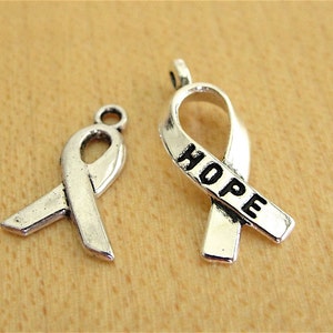 May include: Two silver ribbon charms, one with the word "HOPE" engraved on it.