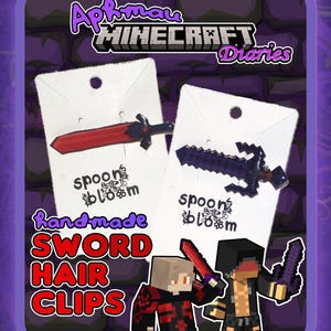 May include: Two handmade sword hair clips on white cards. One clip is red, the other is black. The text "Aphmau Minecraft Diaries" and "spoon bloom" are visible. The image also includes cartoon characters holding swords.