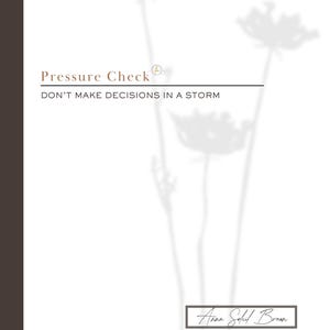 May include: A white journal with the text "Pressure Check" and "DON'T MAKE DECISIONS IN A STORM" in a serif font. The journal features a brown border on the left side and a floral shadow design. The author's name, Anna Soleil Brown, is at the bottom.