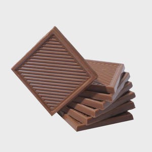May include: A pile of square, brown chocolate pieces. Each piece features a diamond shape with a ridged pattern. The chocolate is a medium brown colour and appears neatly stacked, with one piece angled.