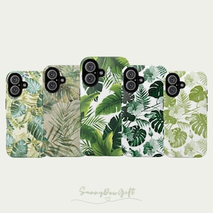 May include: Five phone cases with tropical leaf designs in shades of green and white are displayed. The cases feature various leaf patterns, including large monstera leaves and delicate fern fronds. The cases are arranged in a row, showcasing the different designs.