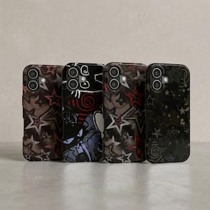 May include: Four rectangular smartphone cases arranged in a row. Each case features a distinct dark-themed graphic design with various star and spiral patterns in shades of black, gray, white, and red, including one with a stylized character face.
