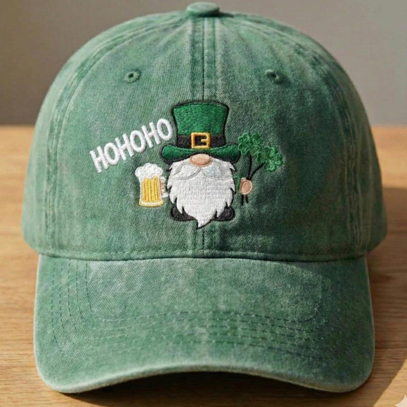 May include: Green baseball cap with a distressed finish. The cap features an embroidered design of a gnome holding a beer stein and a sprig of shamrocks. The word "HOHOHO" is embroidered above the gnome.