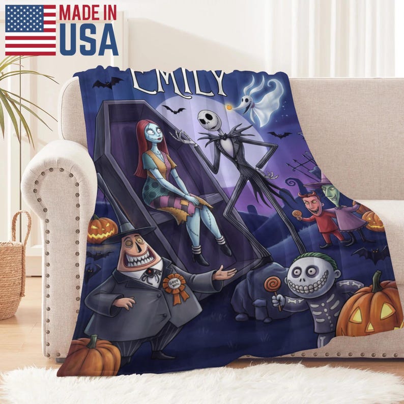 Puede incluir: Una manta de felpa con una colorida ilustraci&oacute;n de personajes de The Nightmare Before Christmas. La manta muestra a Jack Skellington, Sally y otros personajes sobre un fondo p&uacute;rpura oscuro. El texto "EMILY" es visible.