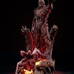 Puede incluir: Escultura detallada de un monstruo con rostro esquelético y cuerpo cubierto de enredaderas, de pie sobre una base rocosa. Una criatura Demogorgon está en la base. La escultura tiene una estética oscura y ominosa, con iluminación roja.