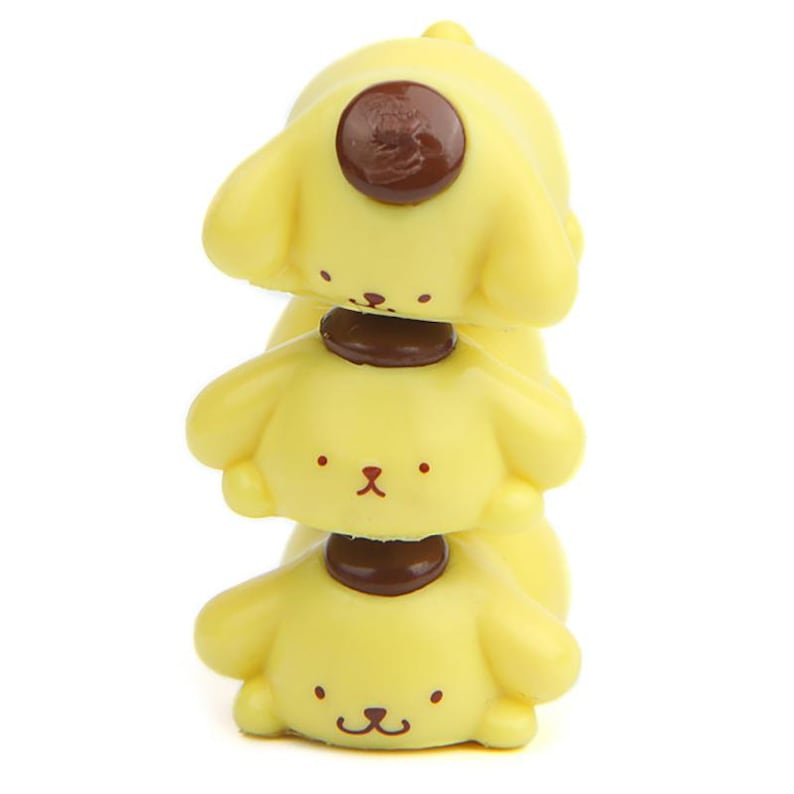 A stack of three yellow rubber duckies with brown spots on their heads.