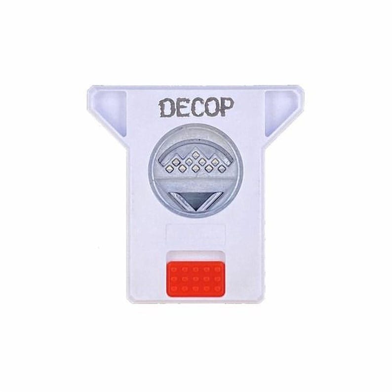 a white plastic device with a red button and the word "DECOP" printed on it.