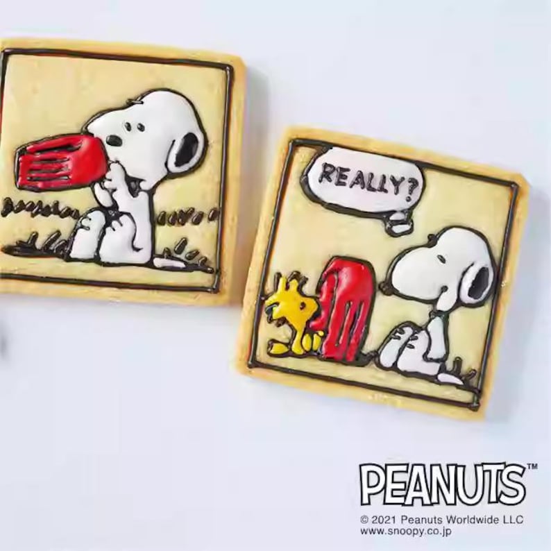 two cookies decorated with the characters from the Peanuts comic strip.