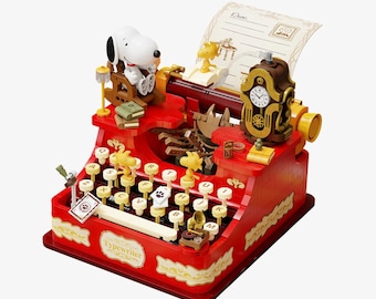 Juego de bloques de construcción Peanuts, escena con figuras en miniatura móviles y máquina de escribir de Snoopy.