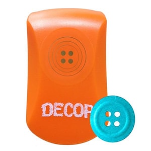 May include: An orange button-shaped object with the word "DECOR" in white text. A teal blue button with four holes is next to the orange object. The orange object has a circular design with four brown dots.