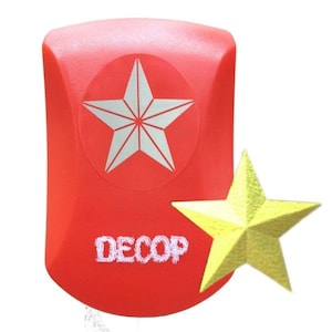 May include: A red craft punch featuring a white star design and the word "DECOP" in white. A separate yellow star is next to the punch. The punch is likely used for paper crafts.