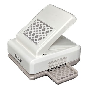 May include: A white and gray Decop paper punch with a decorative lattice design. The punch has a hinged top and a small tray to catch the punched-out shapes. The word "DECOP" is printed on the side.