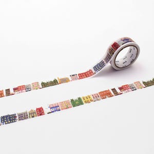 May include: A roll of decorative washi tape featuring a repeating pattern of colorful buildings. The tape is white with a variety of building designs in shades of red, blue, green, and yellow. The tape is ideal for scrapbooking and crafts.