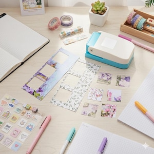 May include: A collection of stationery supplies, including notebooks, pens, decorative tape, stickers, and floral-themed paper cutouts. A blue and white hole punch is also present. The items are arranged on a light-colored wooden surface.