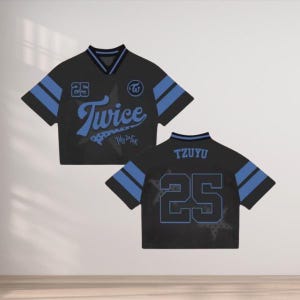 May include: Black and blue cropped jersey with the word "Twice" in a script font. The jersey has blue stripes on the sleeves and the number "25". The back of the jersey has the name "TZUYU" and the number "25".