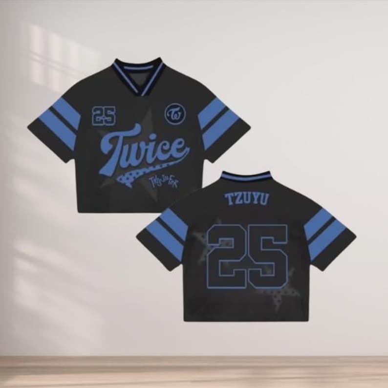 May include: Black and blue cropped jersey with the word "Twice" in a script font. The jersey has blue stripes on the sleeves and the number "25". The back of the jersey has the name "TZUYU" and the number "25".