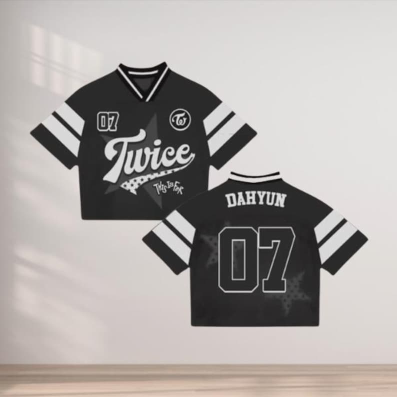 May include: Black cropped jersey with white stripes on the sleeves and collar. The front features the word "Twice" in a script font, the number "07", and a star graphic. The back displays "DAHYUN" and the number "07".
