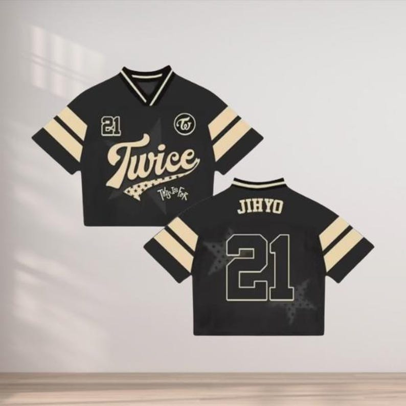 May include: Black and beige cropped jersey with the word "Twice" in a stylized font, the number "21", and a star graphic. The jersey has beige stripes on the sleeves and collar. The back of the jersey displays the name "JIHYO" and the number "21".