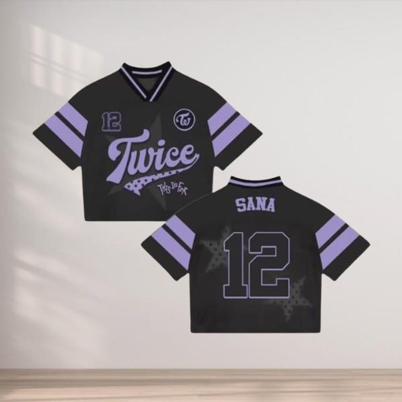 May include: Black cropped jersey with purple accents. Features the word "Twice" in a stylized font, the number "12", and the name "Sana" on the back. Includes a star design and a logo.