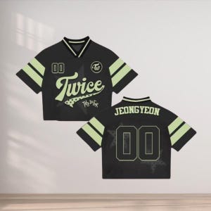 May include: Black short-sleeved jersey with the word "Twice" in a stylized font, a star graphic, and the number "00". The jersey has light green stripes on the sleeves and a white collar. The back of the jersey has the name "JEONGYEON" and the number "00".