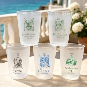 May include: Five frosted plastic cups featuring custom illustrations of dogs and cats. Each cup displays a unique pet portrait in green, blue, or black ink, accompanied by text such as Drinks on me!, Cheers!, and personalized names and dates.