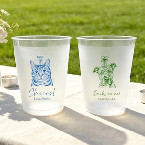May include: Two frosted plastic cups featuring custom illustrations. The left cup has a blue cat graphic with the text "Cheers! Love, Simba". The right cup has a green dog graphic with the text "Drinks on me! LOVE, MOLLY". Both cups feature a small martini glass icon.