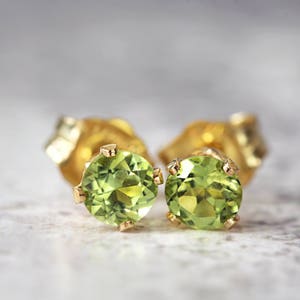 Handmade gold fill stud earrings featuring faceted bright green peridot gemstones in a prong setting. Round in shape, with ear post fitting and matching butterfly backs. The earrings are simple minimal and elegant in style, and come in various sizes.