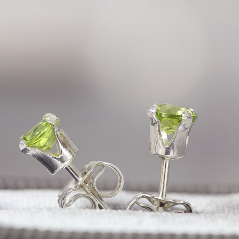 Simple, minimal round stud earrings made with aquamarine gemstones set into sterling silver ear posts. Available in various sizes including 3 milimetres diameter, 4 milimetres diameter, 5 milimetres diameter and 6 milimetres diameter.