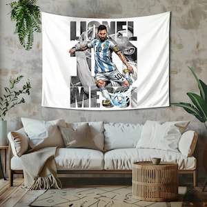 May include: White wall tapestry featuring a graphic of a soccer player in a blue and white striped jersey kicking a soccer ball. The player's name, "Lionel Messi," is printed in large letters. The tapestry is hanging on a textured wall.