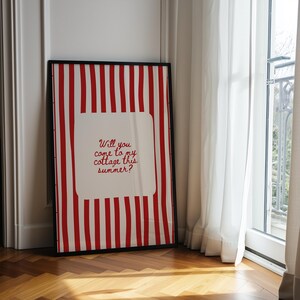 May include: Framed art print with a red and white striped background and the text "Will you come to my cottage this summer?" in red script. The print is in a black frame and leans against a white wall.