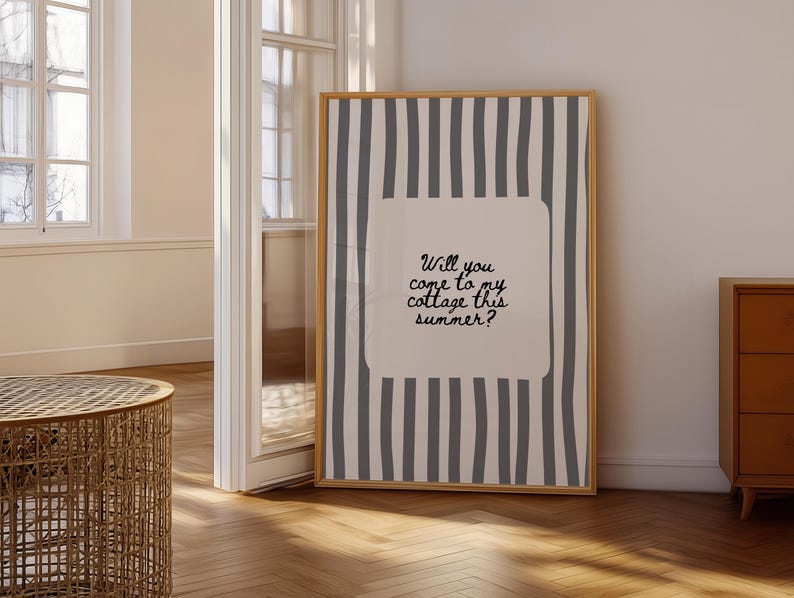 May include: A framed art print with a wooden frame. The artwork features a beige background with vertical gray stripes. A central beige rectangle contains the handwritten text: "Will you come to my cottage this summer?"