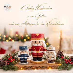 May include: Three nutcracker figurines in red, blue, and white with heart-shaped details. The text reads: Chubby Nussknacker in zwei Größen auch zum Aufhängen für den Weihnachtsbaum. The figures have white hair, mustaches, and uniform-style hats.
