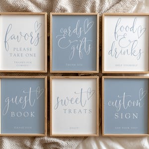 Peut inclure: Six panneaux encadrés avec des cadres en bois. Les panneaux ont un fond blanc ou bleu avec une écriture blanche élégante. Le texte comprend "Favors, Please Take One", "Cards & Gifts, Thank You", et "Food & Drinks, Help Yourself".